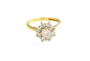 An 18 Carat Gold Diamond Cluster Ring, the central raised round brilliant cut diamond within a