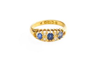 An 18 Carat Gold Sapphire and Diamond Ring, three oval cut sapphires spaced by pairs of old cut