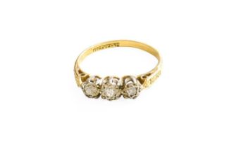 A Diamond Three Stone Ring, the graduated old cut diamonds in white illusion settings, to a yellow