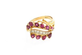 A 14 Carat Gold Ruby and Diamond Ring, a row of round brilliant cut diamonds in white claw and