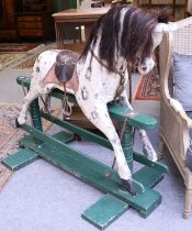 An Early 20th Century Dappled Grey Rocking Horse, with leather tack and horsehair mane on a green