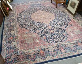 Kirman Carpet, the indigo field of scrolling vines around an ivory medallion framed by raspberry