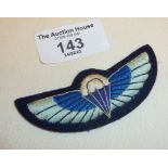 An SAS cloth wings badge, pale blue on a dark felt-type backing