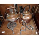 Two Victorian copper kettles and two iron trivets