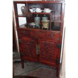 Early 20th c. Chinese carved and red lacquered cabinet having shelves, three drawers and two