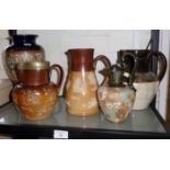 Four various Doulton stoneware jugs and a similar vase