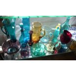 Sixteen various coloured glass jugs, vases and bottles