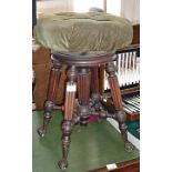 Victorian revolving piano stool with upholstered seat above turned and fluted legs with cast iron