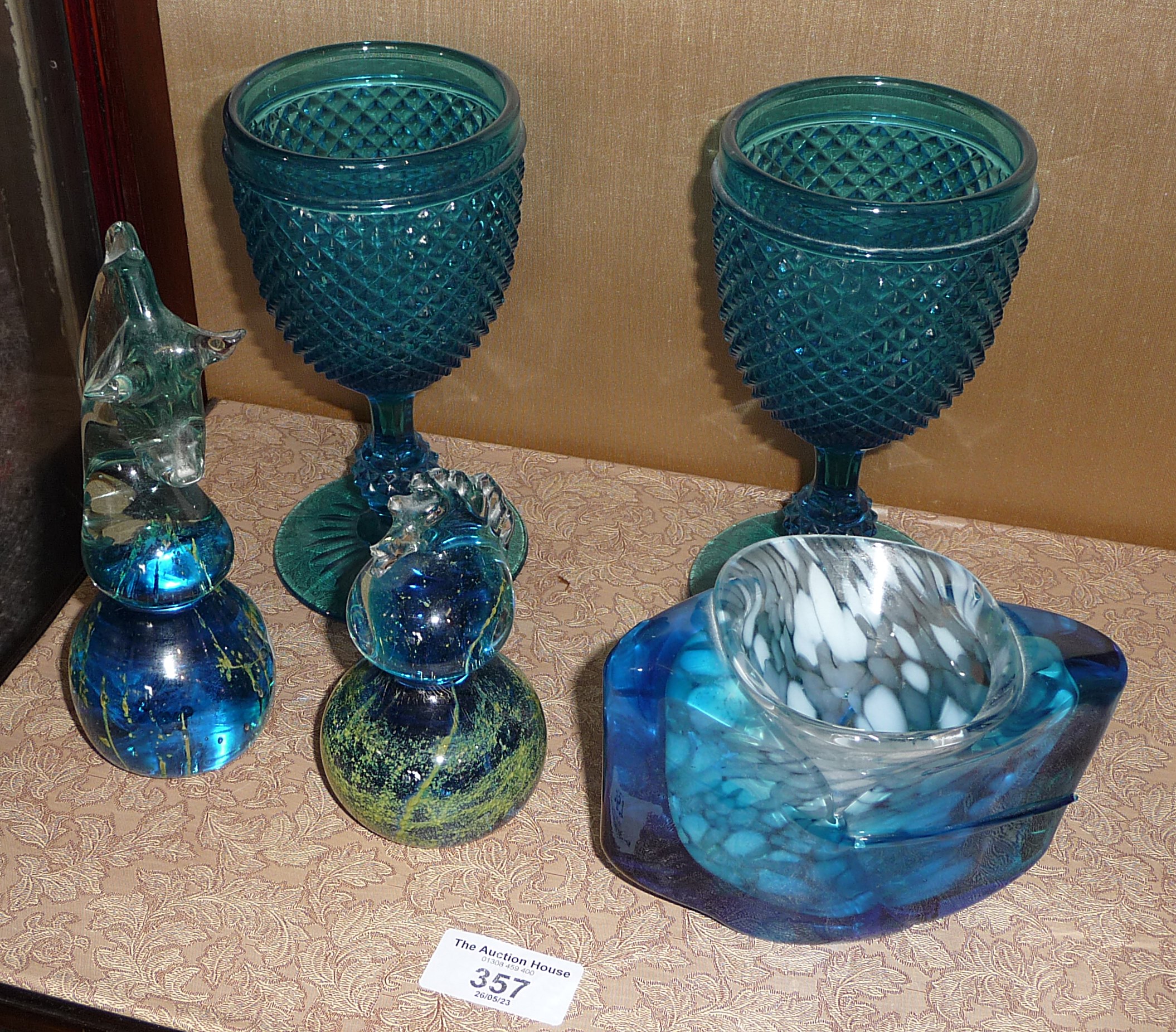 Two Mdina glass sea horse paperweights, pair of blue glass goblets and another glass item