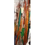 Large collection of various fishing rods, poles, rod rests, an umbrella and keep net