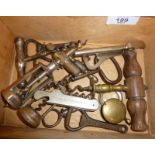 Old corkscrews and bottle openers in a wooden box.