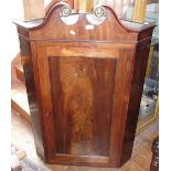 Fine Georgian flame mahogany corner cupboard with single door having swan necked pediment and shaped