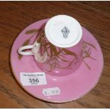 Scarce E.J.D. Bodley of Burslem porcelain cup and saucer. The pink glazed cup having a swan handle