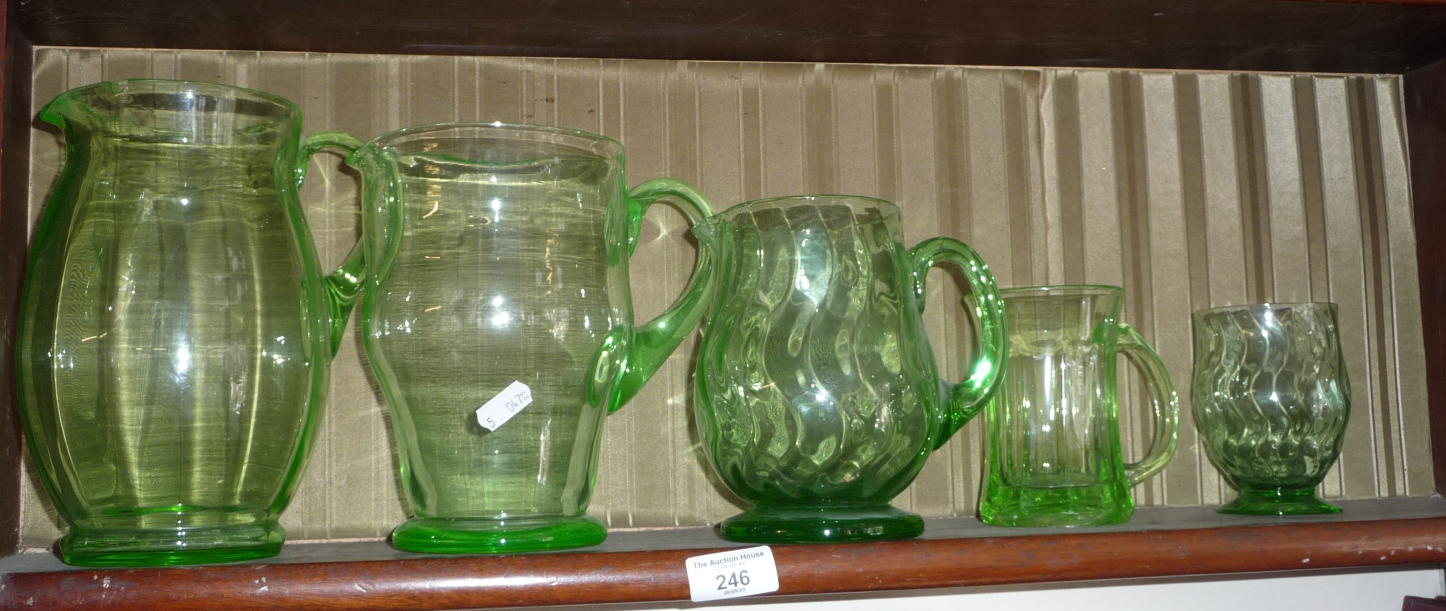 Three uranium glass water jugs, a similar tankard and another