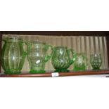 Three uranium glass water jugs, a similar tankard and another