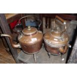 Two Victorian copper kettles and two iron trivets