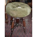 Victorian revolving piano stool with upholstered seat above turned and fluted legs with cast iron