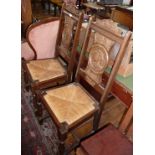 Pair of hall chairs with rush seats and carved backs depicting a Breton man and his wife