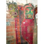 Two painted wood masks and a prayer mat