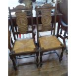 Two carved hall chairs with carved portraits of a Breton man and wife