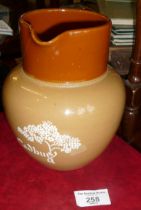 Stoneware milk jug with slip trailed name "Cadbury"