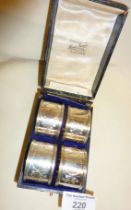 Cased set of four numbered silver napkin rings engraved with an Art Nouveau foliate pattern.