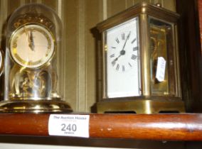Brass carriage clock and a Shatz 8 day clock under a dome