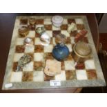 Onyx chess board with a collection of small glass and metal ornaments and boxes