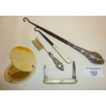 Button hooks, one with silver handle, small silver-handled brush, fruit knife and a celluloid pocket