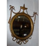19th c. giltwood and gesso round wall mirror with ribbons and swags and having bevelled edge