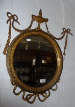 19th c. giltwood and gesso round wall mirror with ribbons and swags and having bevelled edge
