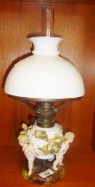 19th c. German porcelain oil lamp with cherubs and chestnuts decoration around reservoir base,