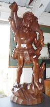 Large carved wood figure of a native carrying a goat, 25" tall