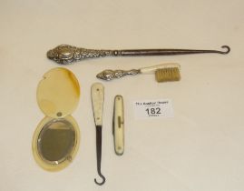 Button hooks, one with silver handle, small silver-handled brush, a fruit knife and a celluloid