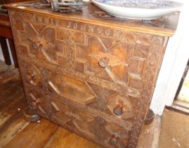 Unusual early carved oak dowry chest of drawers with two lift-up sections, having all over carving