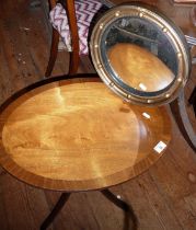 An oval mahogany tilt-top wine table and a convex wall mirror