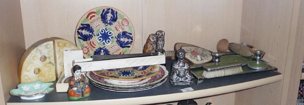 Shelf of mixed items including Buddhas, marble bookends in the form of Edam cheese wedges with