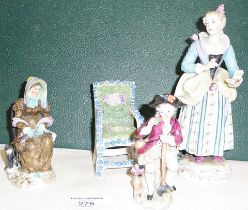 Three porcelain figurines and a porcelain moss and flower covered chair