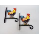 Two cast iron flower basket hangers with cockerel decoration,