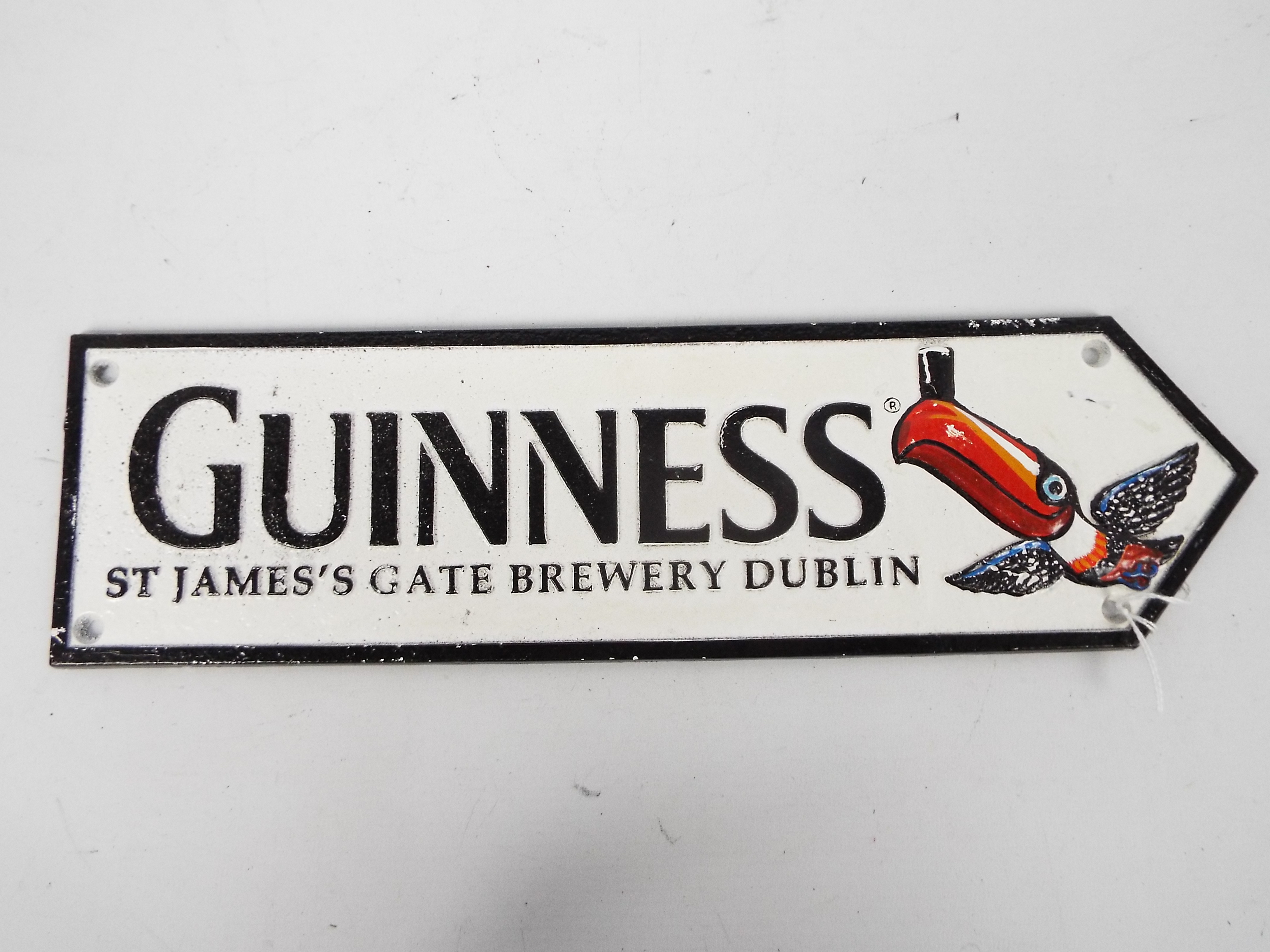 A cast iron directional sign, marked Guinness with toucan decoration, 11 cm x 38 cm,