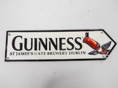 A cast iron directional sign, marked Guinness with toucan decoration, 11 cm x 38 cm,