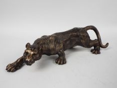 A bronzed, cast iron figure of a female lion, approximately 40 cm (l),