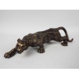 A bronzed, cast iron figure of a female lion, approximately 40 cm (l),