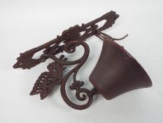 A cast iron, wall mountable, bell with butterfly decoration, approximately 34 cm (h),