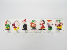 A cast iron, wall mountable, key or cup holder depicting The Seven Dwarfs,