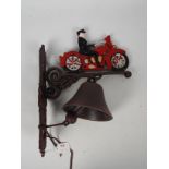 A wall mountable, cast iron bell with motorcyclist surmount, approximately 35 cm (h),