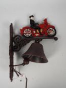 A wall mountable, cast iron bell with motorcyclist surmount, approximately 35 cm (h),