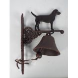 A cast iron, wall mountable, bell with canine surmount, approximately 36 cm (h),