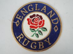 A cast iron wall plaque marked England Rugby, 23 cm (d),