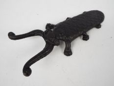 A cast iron boot jack in the form of a beetle, approximately 30 cm (l),